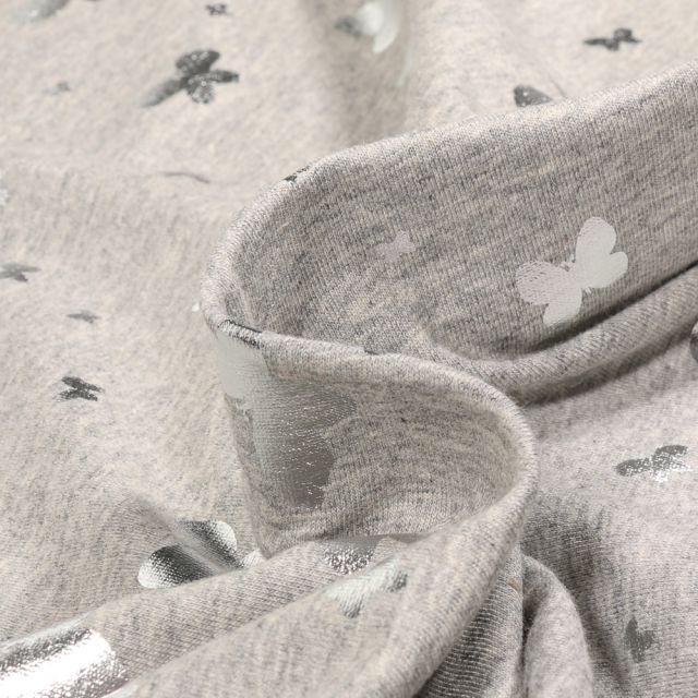 Tissu Jersey Coton Papillons métalissés sur fond Gris clair chiné