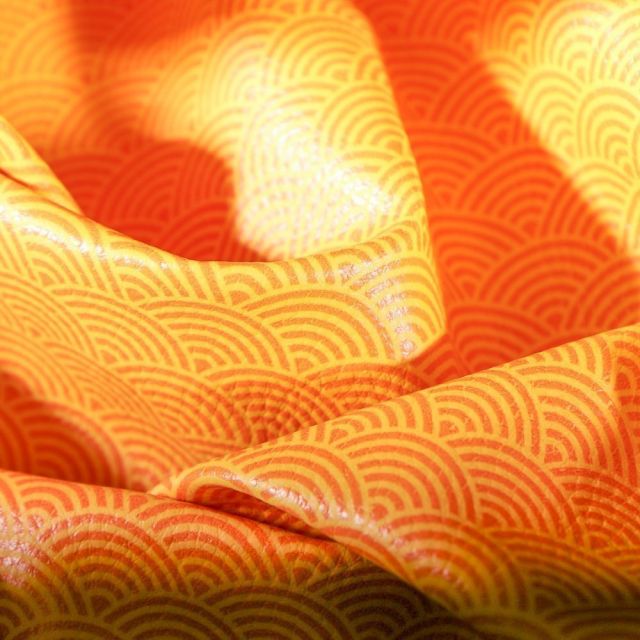 Simili cuir d'ameublement Eventails oranges sur fond Jaune curry - Par 50 cm